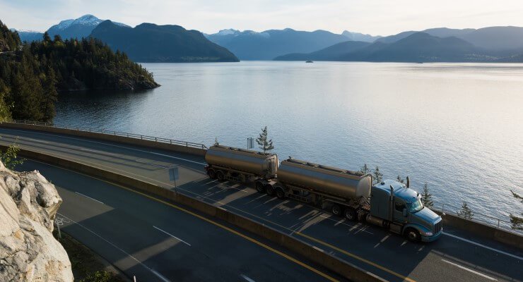 Truck on road near lake and mountains